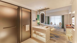 A hotel room with a large bed, a vanity with a mirror, a desk, and a television. - Ramada Plaza By Wyndham Wuhan Dongxi Lake (Wuhan)