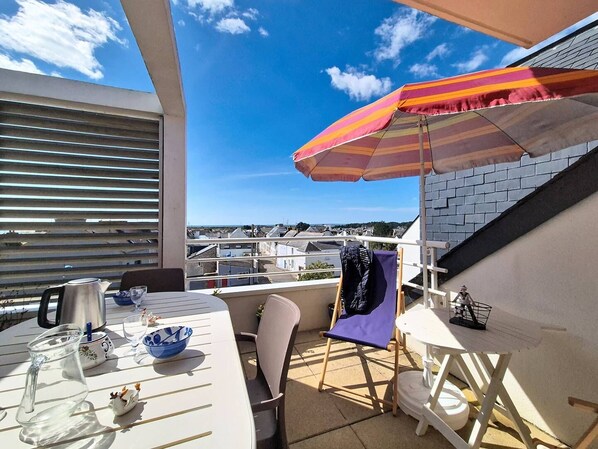 Ein Balkon mit Tisch, Stühlen, einem Wasserkocher und Blick auf die Stadt.