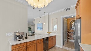 A modern kitchen with wooden cabinets, a stainless steel refrigerator, and a built-in dishwasher.