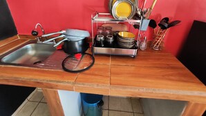 Eine Küche mit Spüle, Herd und Geschirrgestell.