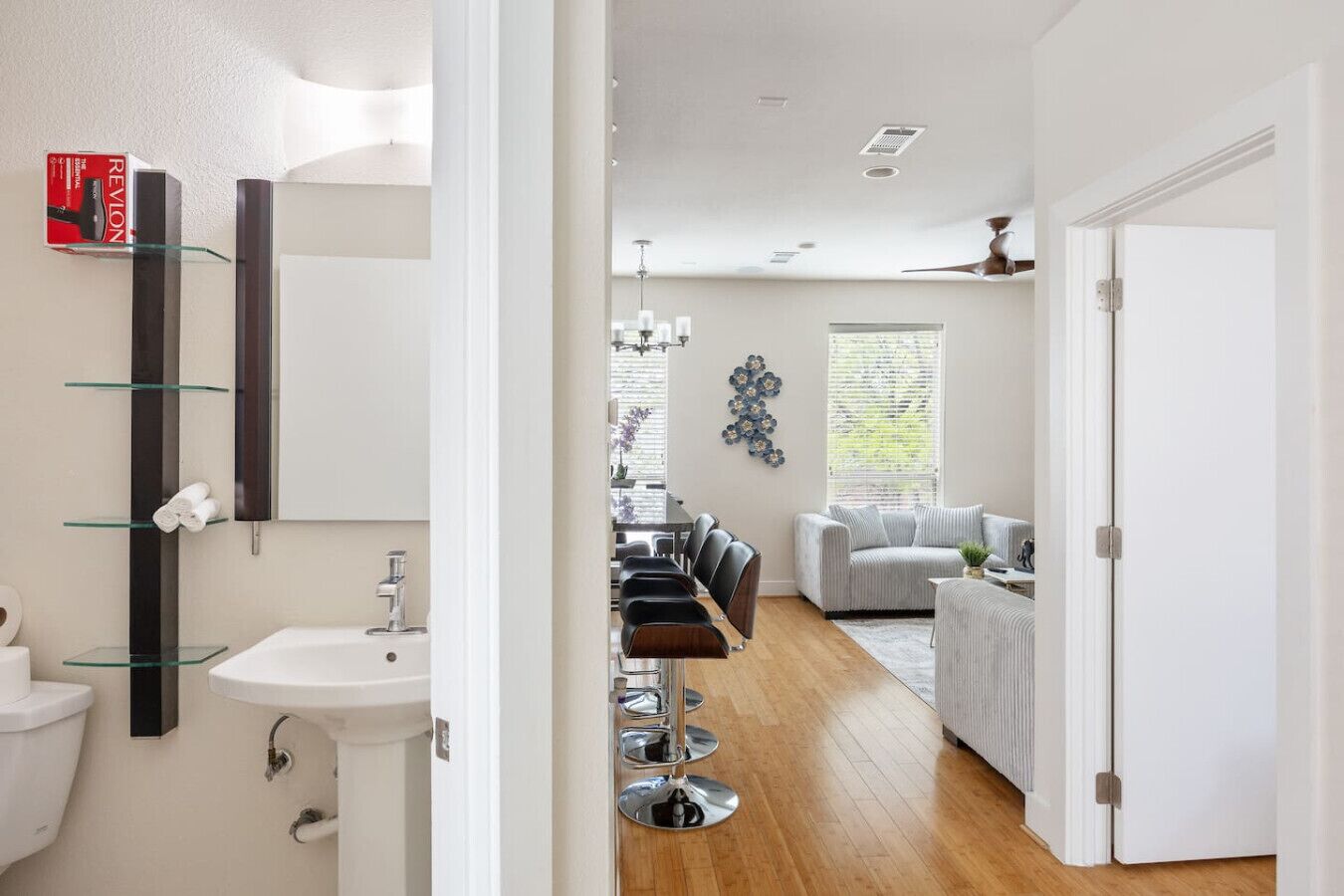 A modern bathroom with a glass shelf, a mirror, and a sink.