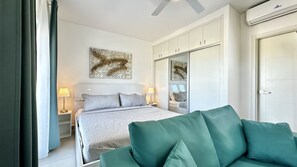 Une chambre d’hôtel avec un lit, des lampes de chevet, un grand miroir et une armoire.