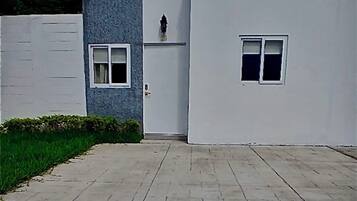 A modern building with a flat roof, a small window, and a door.