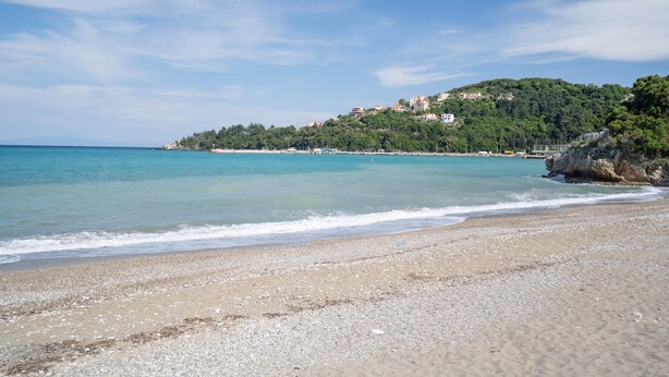 A beach with clear water, a sandy shore, and buildings on a hillside in the background. - Apartment '' with Shared Garden, Wi-Fi and Air Conditioning (Póros Kefalonias)