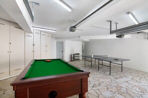 A billiards table, a pool table, and a ping pong table in a room with stone flooring and white walls. - Villa 'Rebelo' with Private Pool, Private Garden and Wi-Fi (Albufeira)