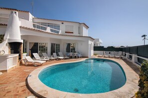 A swimming pool with lounge chairs and a patio area. - Villa 'Rebelo' with Private Pool, Private Garden and Wi-Fi (Albufeira)
