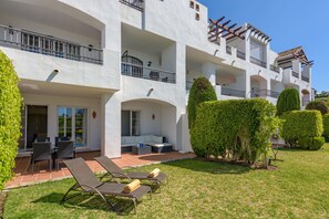 Un hôtel à plusieurs étages doté d’un espace extérieur aménagé, d’une terrasse et d’un jardin paysager bien entretenu.