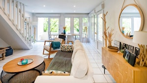 Un vaste espace de vie comprenant un canapé, une table basse et un meuble en bois agrémenté d’objets décoratifs.