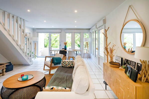 A spacious living area with a sofa, coffee table, and a wooden cabinet with decorative items.