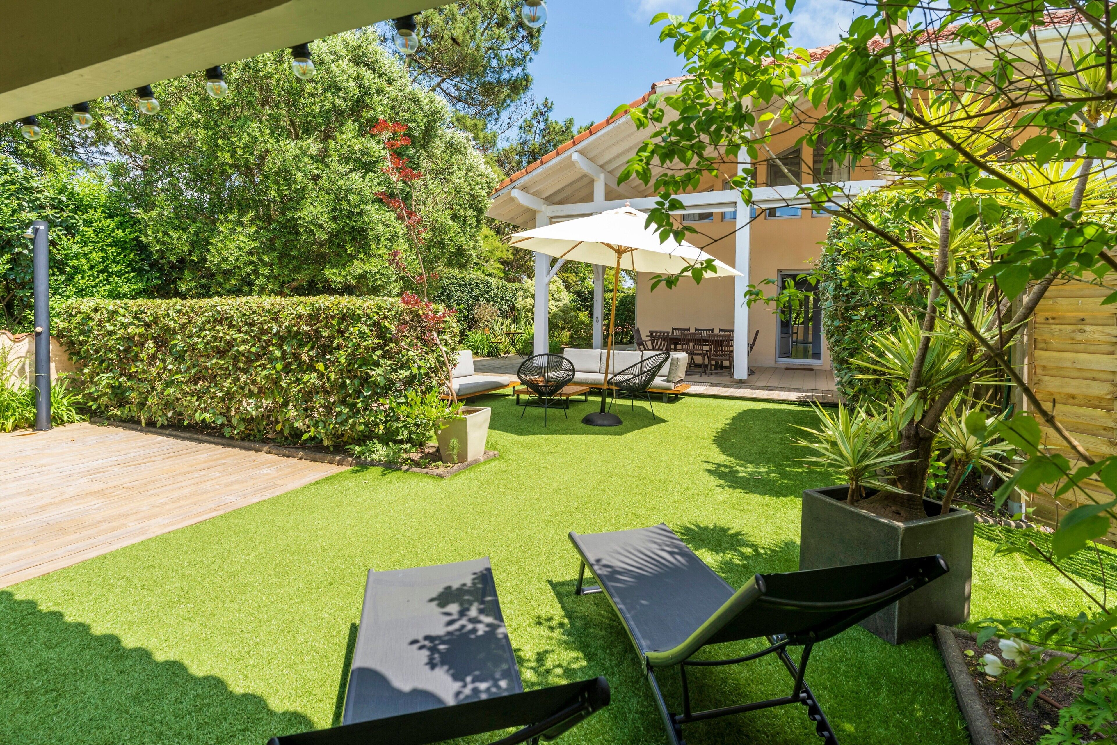 A patio with outdoor furniture, a covered seating area, and a well-maintained lawn.