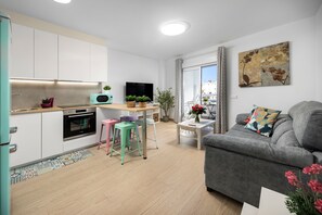 A modern apartment with a kitchen, dining area, and living room.