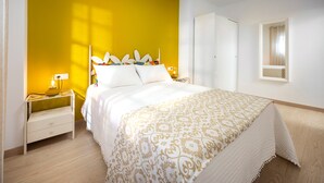 Un dormitorio con cama, mesitas de noche, un armario y una ventana.