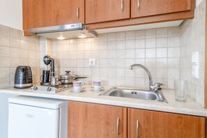 Fridge, stovetop, electric kettle, cookware/dishes/utensils