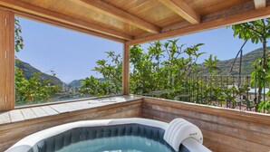 A hot tub with a view of a mountainous landscape through large windows. - Vacation 'Upper House' with Mountain View, Wi-Fi and Air Conditioning (Vega de San Mateo)