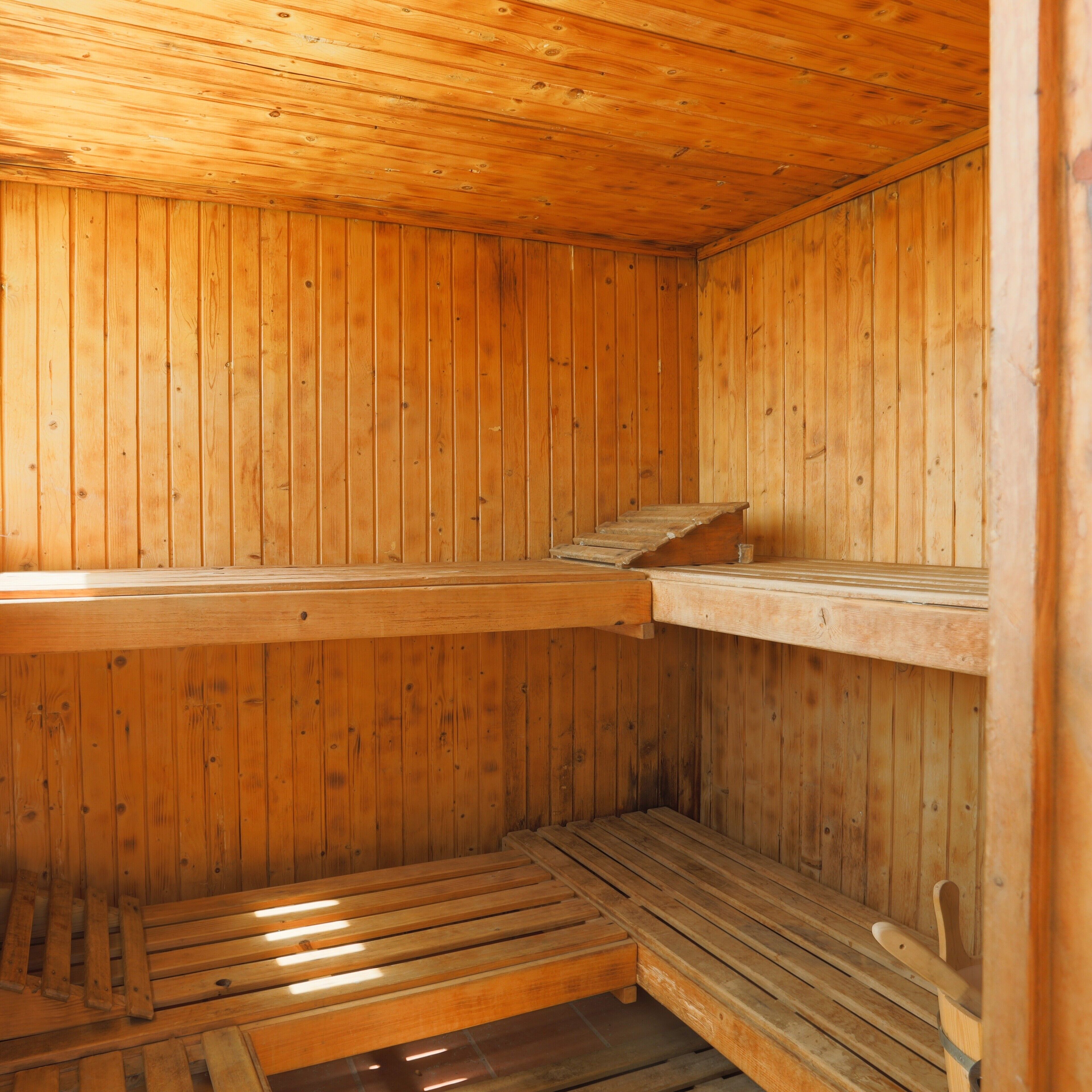 A sauna room with wooden walls and benches.