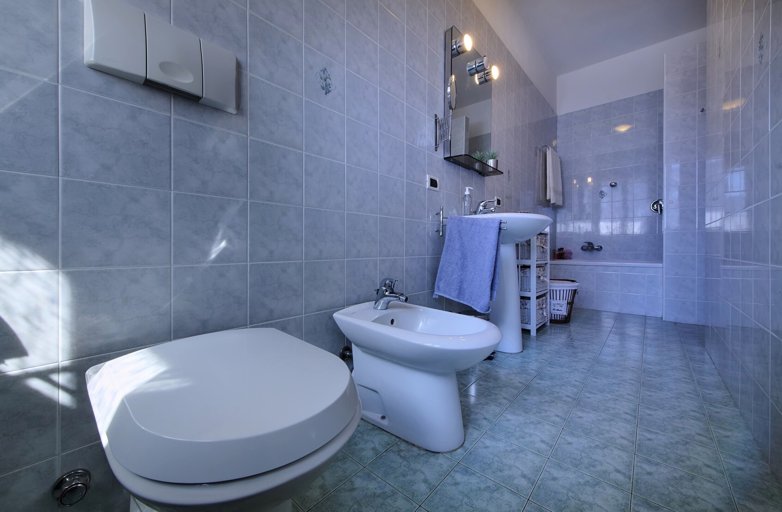 Une salle de bain moderne équipée de toilettes, d’un bidet et d’un lavabo.
