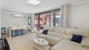 Una sala de estar moderna con un sofá, una mesa de centro y una zona de bar con taburetes.