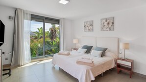 Un dormitorio con una cama, dos mesitas de noche, una ventana con cortinas y una obra de arte en la pared.