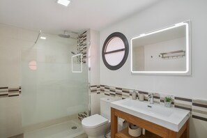 A modern bathroom with a glass-enclosed shower, a toilet, a sink with a mirror, and a towel rack. - Holiday Villa 'Alexandria's Retreat' with Sea Views, Wi-Fi and Air Conditioning (San Bartolome de Tirajana)