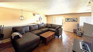 A living room with a sectional sofa, a wooden coffee table, and a flat-screen TV. - Circle Oak Lake View Family Home (Bradley)