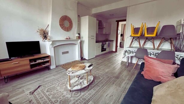 A living room with a TV, sofa, coffee table, and a fireplace.