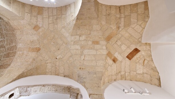 A bathroom with a stone floor, a bathtub, and a toilet with a bidet attachment.