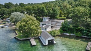 A waterfront property with a dock, a house, and a boat.