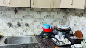Eine Küche mit beigen Schränken, einer Granit-Arbeitsplatte und einer gefliesten Rückwand.
