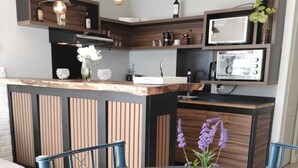 Una cocina moderna con armarios de madera, una isla central e iluminación colgante.