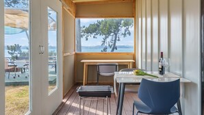 A balcony with a table, chairs, and a grill. - Mu-an Prejong Dokchae Pension (Muan)