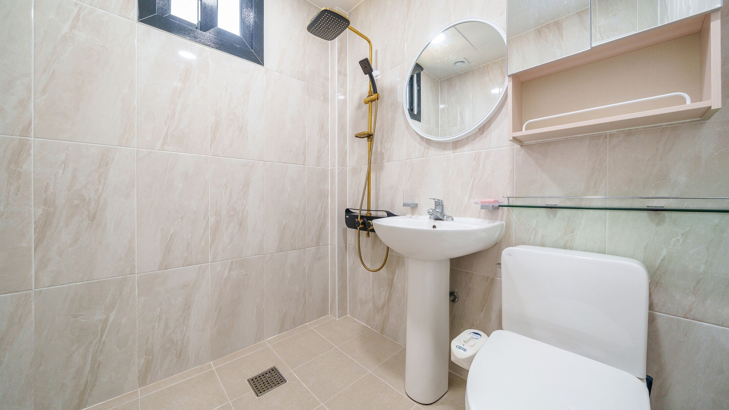 A bathroom with a shower, sink, toilet, and a glass shelf.
