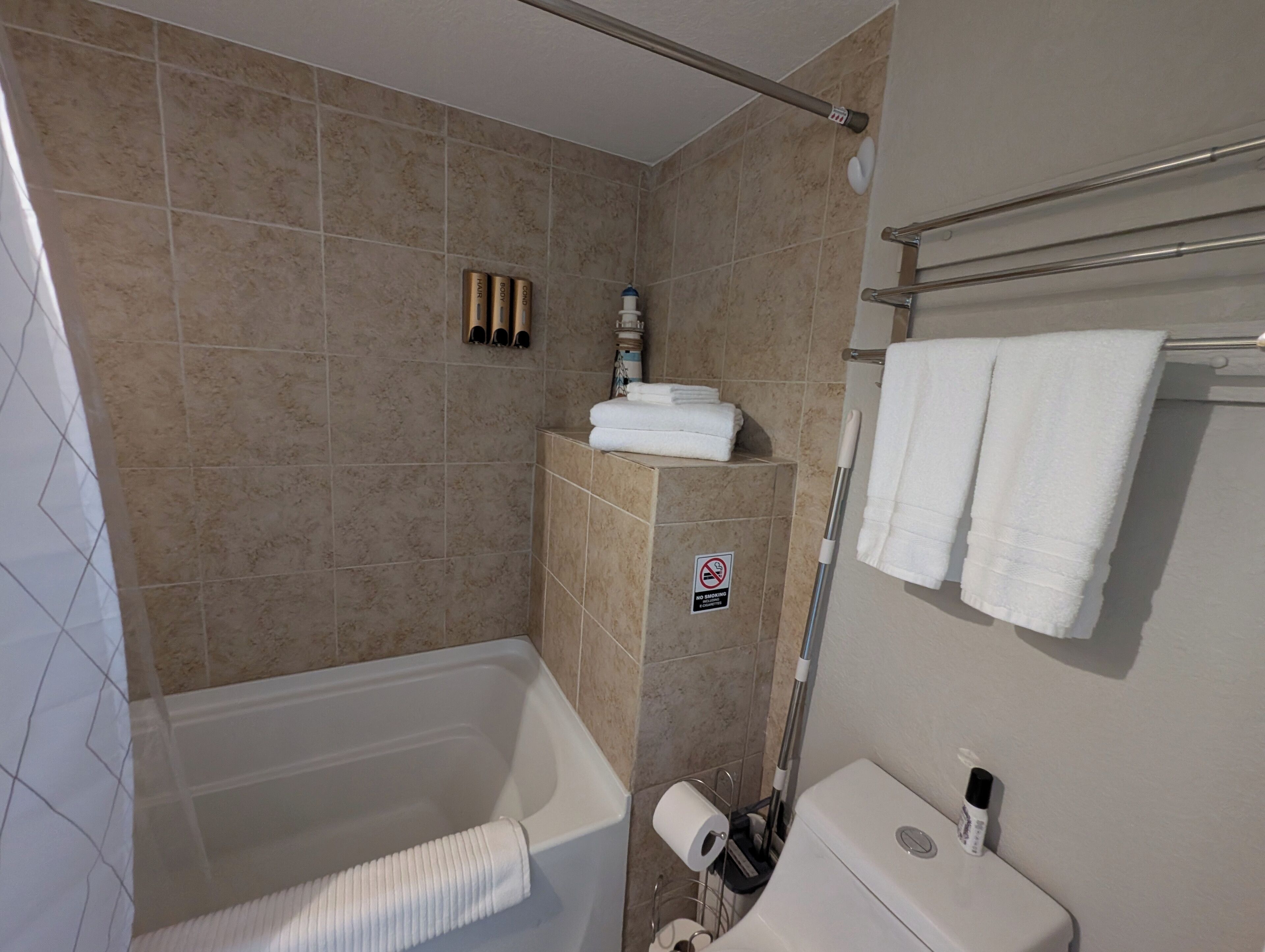 A bathroom with a bathtub, a toilet, and a shower area.