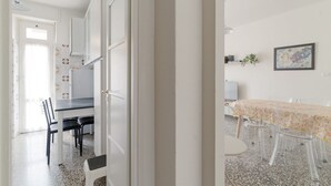 Una habitación con una mesa de comedor, sillas, un televisor y un cuadro en la pared.