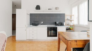 A compact kitchen with white cabinets, a microwave, and a dishwasher. - GuestHost - Cozy 78 sqm apartment, able to accommodate up to 4 people, located on the first floor of a building with lift.The property is located 650m from the Famagosta stop of the green metro line M2, which allows you to reach Piazza Duomo, Central Sta (Milano)