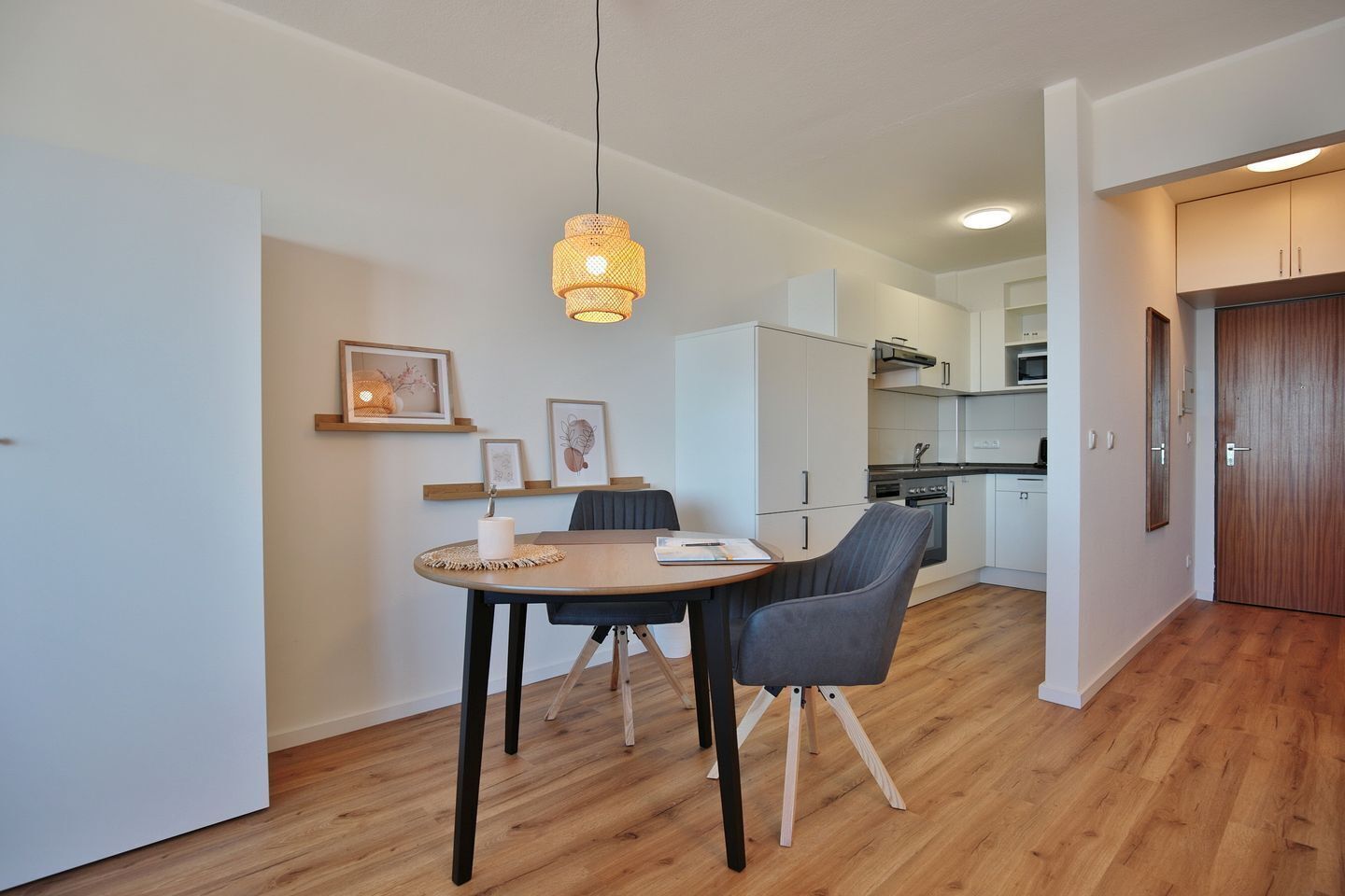 A modern kitchen with white cabinets, a microwave, and a stove.