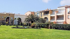 A residential building with multiple balconies, a well-maintained lawn, and a clear sky. - Les Maisons sur la Plage by Interhome (Cap d'Agde)