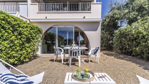 A modern house with a patio area featuring outdoor furniture, a table with drinks, and a large glass door leading to a covered outdoor space. - Les Maisons sur la Plage by Interhome (Cap d'Agde)