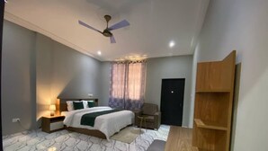 A bedroom with a bed, nightstands, a wooden bench, a ceiling fan, and a door. - DJ Villa Your Premium Stay-NF12 (Dawhenya)