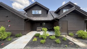 A two-story wooden house with a covered patio, a bench, and a grill. - Gorgeous NEW Trapp Villa: Mountain View, Pool&More (Stowe)