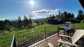 Eine Terrasse mit Sitzgelegenheit und einem schönen Blick auf Wald und Berge.