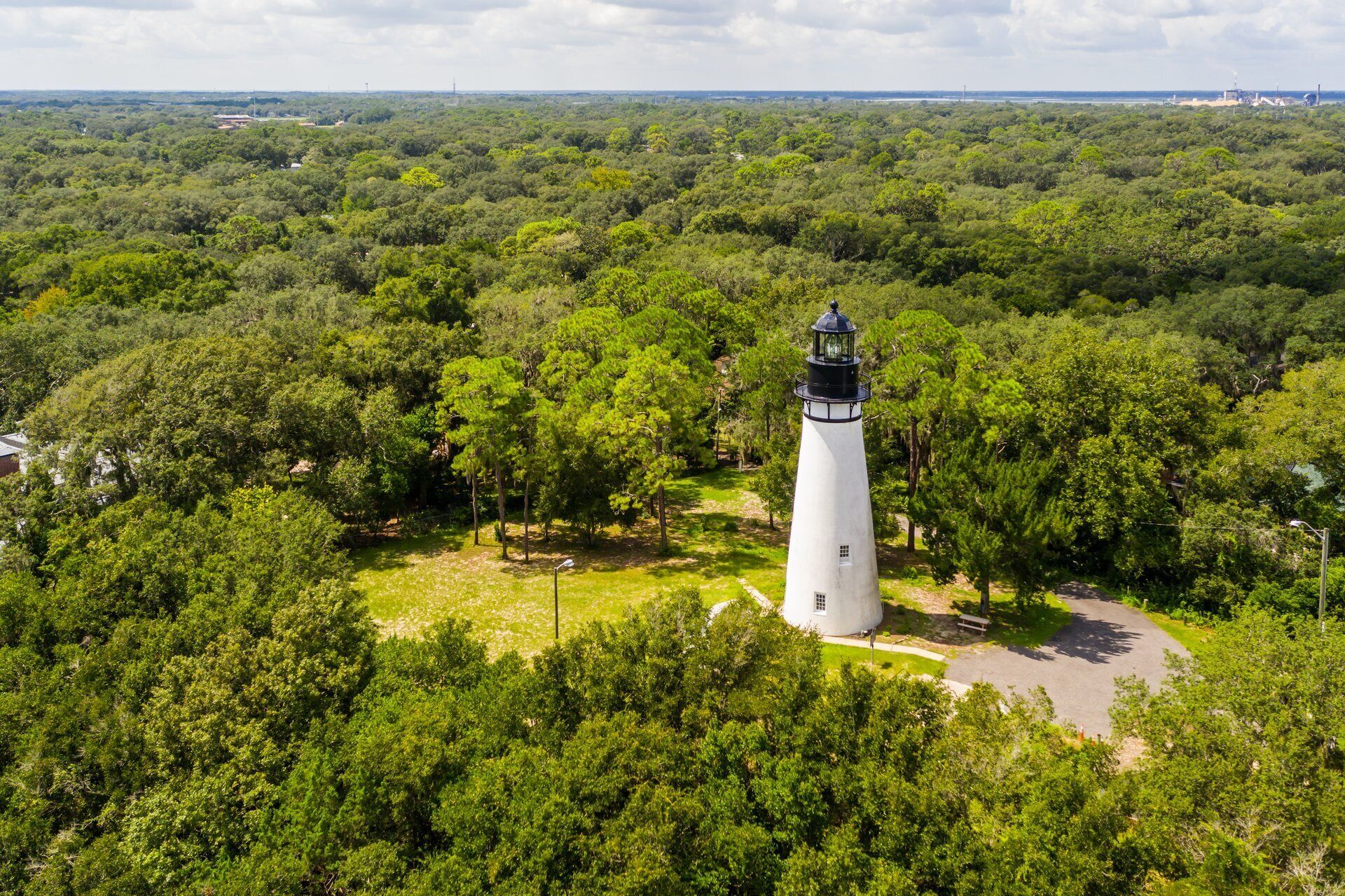 A lighthouse surrounded by dense greenery.