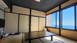 A traditional Japanese room with tatami flooring, a low table, and shoji screens. - Shionomi (Himi)