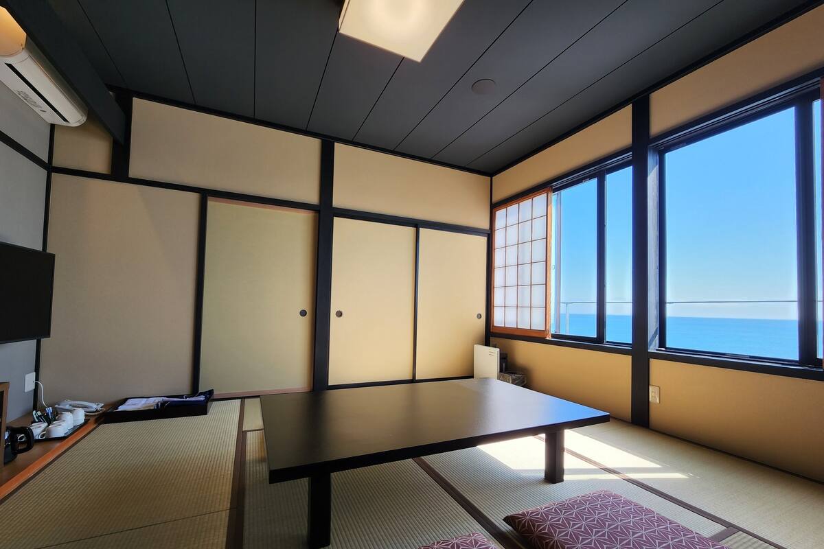 Une pièce de style japonais traditionnel, avec un sol recouvert de tatamis, une table basse et des paravents en papier.