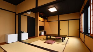 A traditional Japanese room with tatami flooring, a low table, and sliding doors. - Shionomi (Himi)