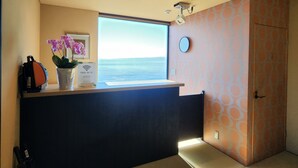 A reception area with a view of the sea, a clock, and a sign indicating free Wi-Fi. - Shionomi (Himi)