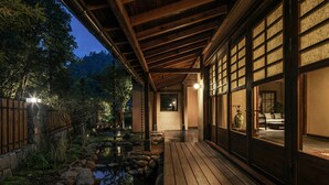 A traditional Japanese-style building with wooden beams and sliding doors, a koi pond, and a stone pathway. - Jingdezhen Xingshan Shiwai Dongliyuan (Jingdezhen)