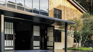 A modern building with large windows, a wooden facade, and a reflective black floor.