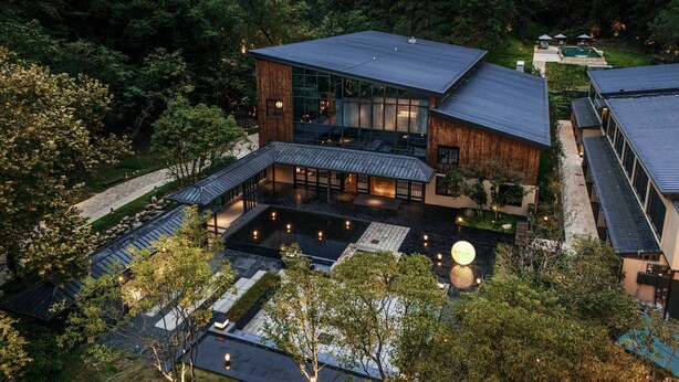 A modern house with a large glass facade, a spacious outdoor area with a pool, and a surrounding forested landscape. - Jingdezhen Xingshan Shiwai Dongliyuan (Jingdezhen)