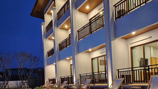 Een hotel met meerdere verdiepingen, een zwembad, terras en balkons.