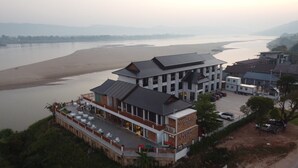 Een hotel met uitzicht op een rivier, diverse eetgelegenheden en een parkeerplaats.